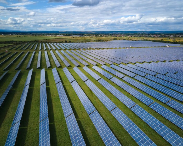 Aerial view of big sustainable electric power plant with many rows of solar photovoltaic panels for producing clean electrical energy. Renewable electricity with zero emission concept.